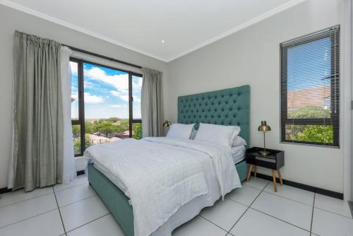 a bedroom with a bed and a large window at Captivating 2-Bed Apartment in Sandton in Sandton