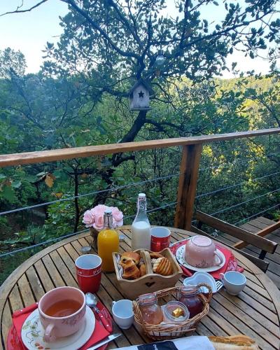 - une table avec un petit-déjeuner composé de café, de croissants et de jus de fruits dans l'établissement La cabane des amoureux, à Barjols