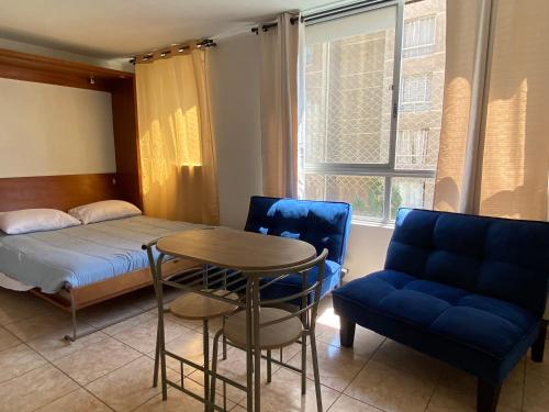 Zimmer mit einem Bett, einem Tisch und Stühlen in der Unterkunft Apartamento completo amoblado Santiago cercano Movistar Arenas in Santiago