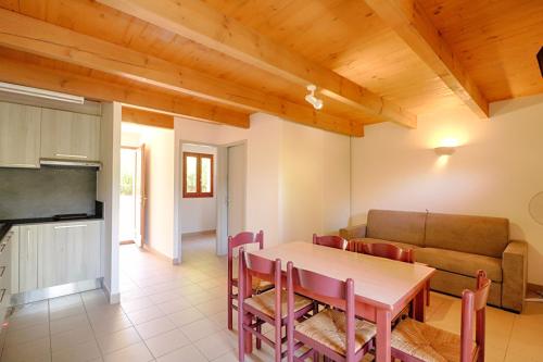 une salle à manger avec une table et un canapé dans l'établissement Appartement n3 rez de jardin LA LISCIA, à Calcatoggio