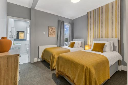 2 Betten in einem Hotelzimmer mit Bad in der Unterkunft Ashby House in Coalville