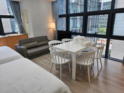 Cette chambre comprend une table et des chaises blanches ainsi qu'un canapé. dans l'établissement Samseong,Coexmall A, à Séoul