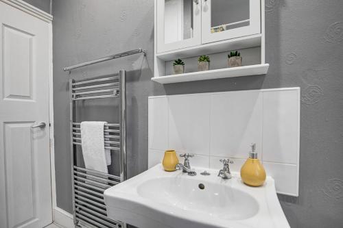 a white bathroom with a sink and a shower at Ashby House in Coalville