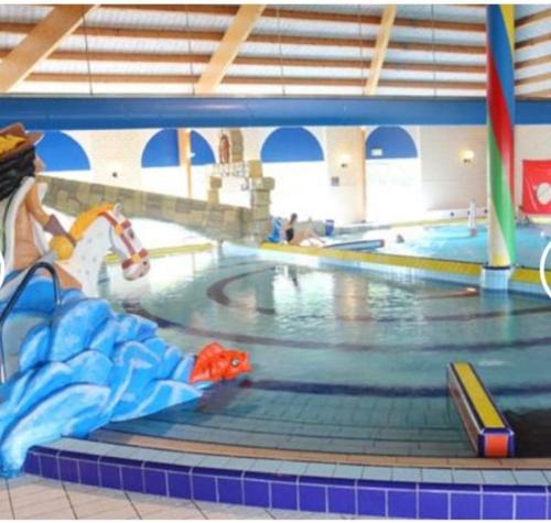 a large swimming pool in a gym with a swimming pool at Een heerlijke vakantiewoning aan de Zeeuwse kust in Breskens