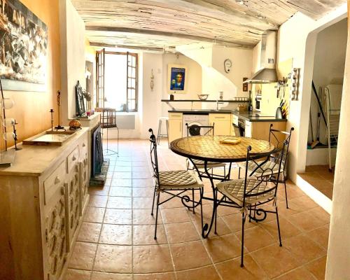 a kitchen with a table and chairs in a room at Coquette maison de village pour 4 pers in Quinson