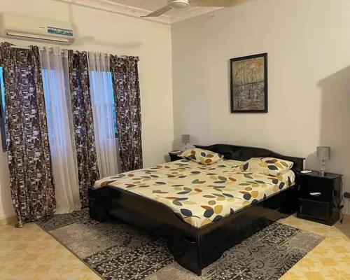 um quarto com uma cama num quarto com cortinas em ATLANTIC APPARTEMENT em Cotonou