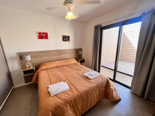a bedroom with a bed with two towels on it at Lumier Apartment 1- Moderno departamento en planta baja, cochera privada in El Challao