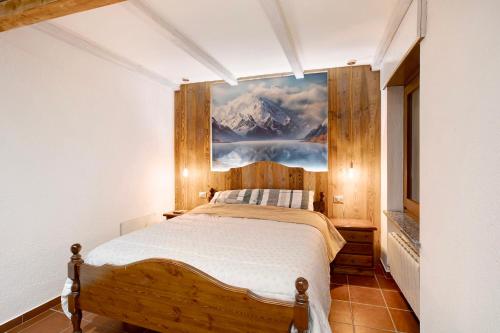 a bedroom with a bed with a painting on the wall at La Casetta in Aosta