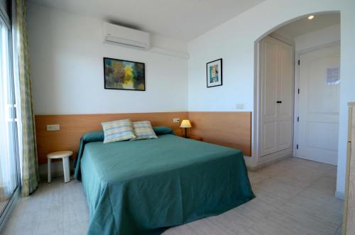 a bedroom with a bed with a green blanket at Treputxell 1-1 in L'Estartit