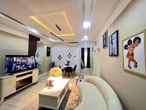 uma sala de estar com um sofá e uma televisão de ecrã plano em MAJESTIC VILLA RESIDENCE em Ankuru