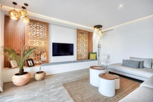 a living room with a couch and a tv at Jad - Luxe - piscine - 6 Px in Agadir