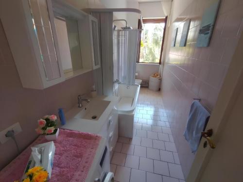 a white bathroom with a sink and a toilet at La casa dei fiori in Florence