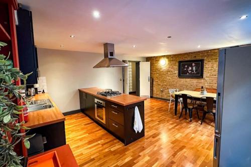a kitchen and dining room with a table and a stove at Luxury Warehouse Conversion - Shoreditch in London