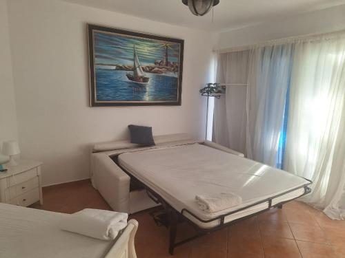 ein Schlafzimmer mit 2 Betten, einem Sofa und einem Gemälde in der Unterkunft Apartamento frente al mar Juan dolio in Juan Pedro