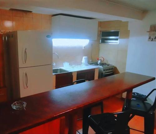 uma cozinha com uma mesa de madeira e uma bancada em María Chusena alojamiento 3 em Fray Bentos