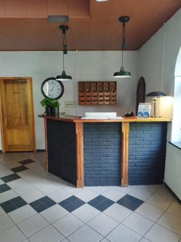 a kitchen with a counter with a clock on the wall at Noclegi Zdrojewo in Nowe
