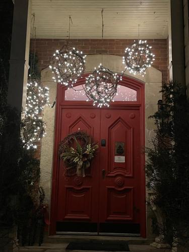 a red door with christmas lights above it at Norfolk Guest House Inn in Guelph