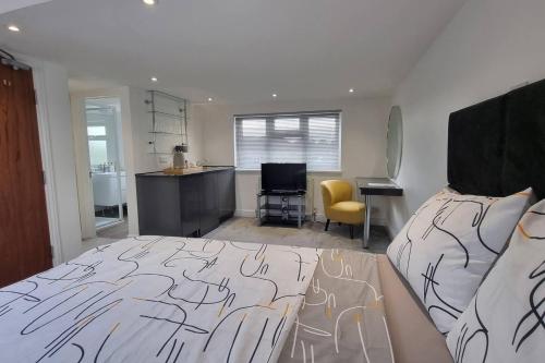a bedroom with a bed and a desk and a kitchen at St Albans Stylish Suite with kitchenette in London Colney