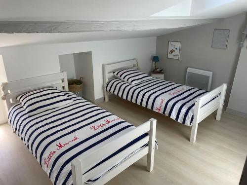 twee bedden naast elkaar in een kamer bij Agréable maison de ville en bord de mer in Royan