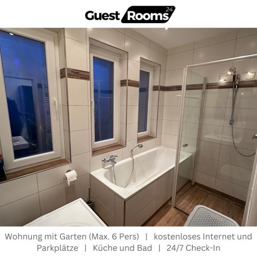 a white bathroom with a tub and a shower at Wohnung mit Garten EG - GuestRooms24 - Marl in Marl