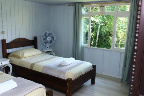 um quarto com 2 camas e uma janela em Recanto Hellmann em Gaspar