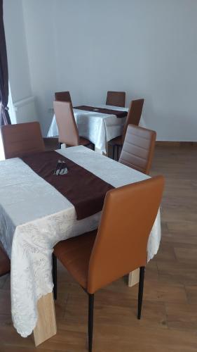 a dining room with two tables and chairs at Pensiunea Agroturistica Daniel in Orăştie