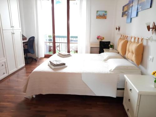 La casa dei fiori في فلورنسا: سرير أبيض كبير في غرفة مع شرفة