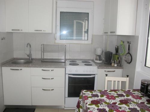 a kitchen with a sink and a stove top oven at Apartment Annika in Tivat