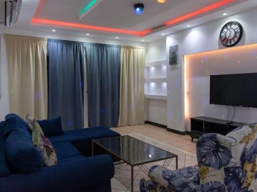 a living room with a blue couch and a tv at شاليه ثلاث غرف نوم في درة العروس in Durat  Alarous