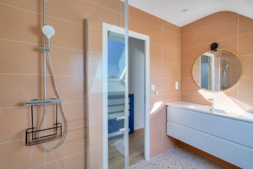 une salle de bain avec une douche, un lavabo et un miroir dans l'établissement Maison en bord de mer pour 4, à Kérity, à Penmarcʼh