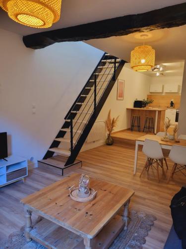 - un salon avec une table en bois et un escalier dans l'établissement Maison de village à la décoration bohème jusqu'à 6 personnes, à Viviers-lès-Montagnes