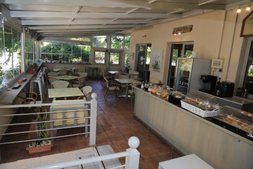 a restaurant with a counter and some tables and chairs at IKAROS Hotel ELLINIKO in Athens