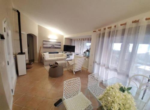 a living room with a couch and a table and chairs at Villetta Isor con piscina in Costa Paradiso