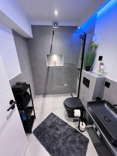 a bathroom with a black toilet and a sink at Rü-Premium Apartments in Essen