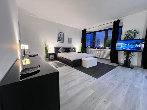 a living room with a bed and a flat screen tv at Rü-Premium Apartments in Essen