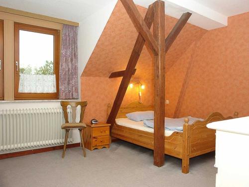 a bedroom with a wooden bed and a chair at Ferienhof Jens Ferienwohnung 3 in Kronsgaard