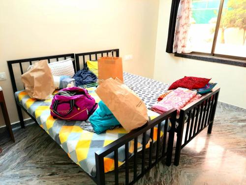 een bed met boodschappentassen en tassen erop bij Shiv villa in Saralgaon