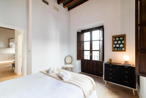 Habitación blanca con cama y ventana en Apartamento Gracia, en Granada