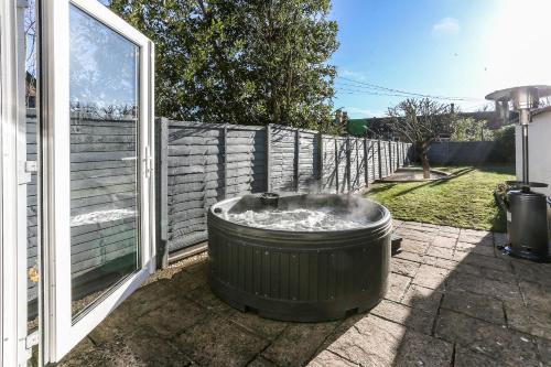 a garbage can sitting on a patio next to a fence at Garden Apartment with hot tub in Bath