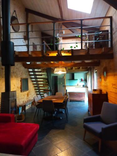 un salon avec une table et une mezzanine dans l'établissement le Roc blanc, à Veyrignac