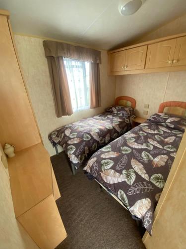 a small room with two beds and a window at The Grange - Ingoldmells - Fantasy Island in Ingoldmells