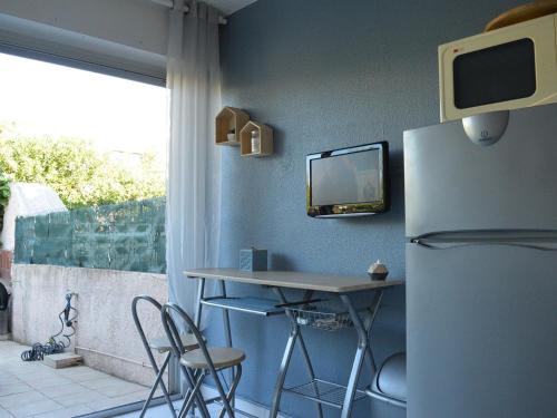 une cuisine avec une table et un réfrigérateur dans l'établissement Studio Cabine 3 Couchages avec Terrasse, Parking, à 50m de la Plage - Le Grau d'Agde - FR-1-249-171, au Grau-dʼAgde