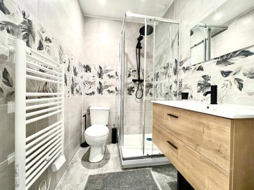 a bathroom with a shower and a toilet and a sink at La Ribaudière Maison de ville à 5 min Futuroscope in Chasseneuil-du-Poitou