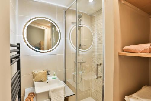 a bathroom with a shower and a sink and a mirror at Résidence Pierre & Vacances Centre in La Rochelle