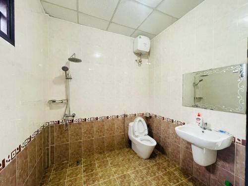 a bathroom with a toilet and a sink at Sibling House in Hue