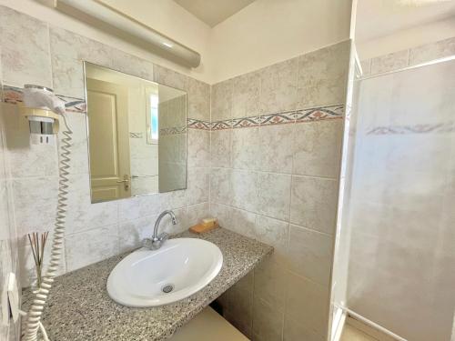 une salle de bain avec un lavabo et un miroir dans l'établissement Appartement Bella Vista 905 PORTICCIO, à Porticcio
