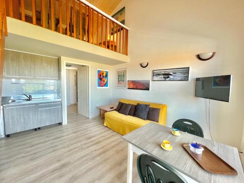 Il comprend un salon avec un lit jaune et une cuisine. dans l'établissement Appartement Bella Vista 905 PORTICCIO, à Porticcio