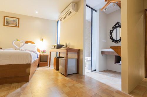 1 dormitorio con cama, lavabo y espejo en At Samui Boutique Hotel, en Chaweng