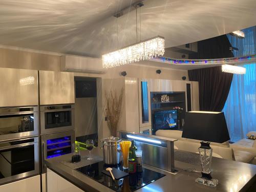 a kitchen with a counter top and a living room at Top-notch apartment with sea view, bbq and Jacuzzi in St Julian's