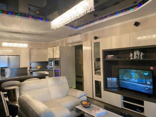 a living room with a white couch and a flat screen tv at Top-notch apartment with sea view, bbq and Jacuzzi in St Julian's